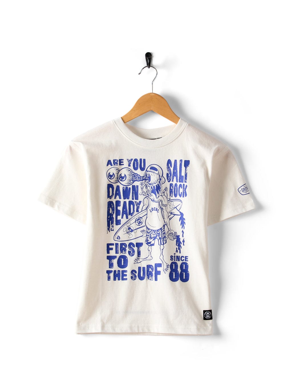 The Saltrock Dawn Ready Kids T-Shirt in white features blue surf-inspired graphics and phrases like “Are you dawn ready?” and “Salt Rock, first to the surf since ‘88.” Made from 100% cotton and machine washable.