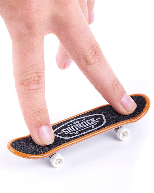 A person is holding a Saltrock mini skateboard in the Hibiscus - Digit Decks - Pink design.