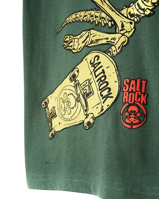 A cool and stylish Saltrock Dinosk8 - Kids Short Sleeve T-Shirt - Green featuring a dinosaur riding a skateboard.
