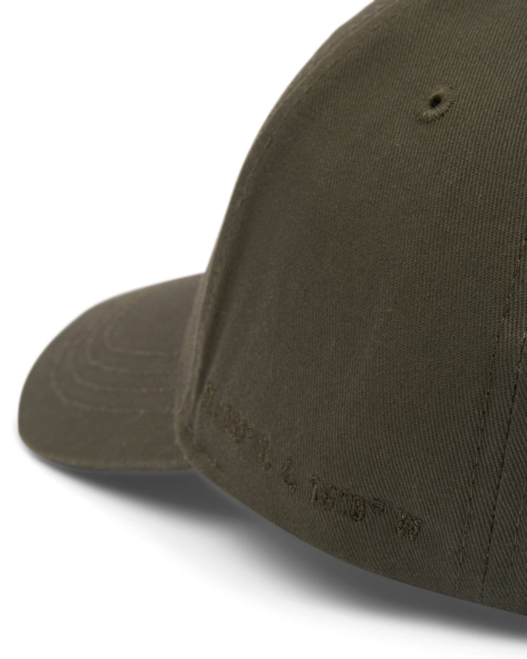 Close-up view of a plain olive green Dockyard baseball cap with an embroidered Saltrock badge on the side.