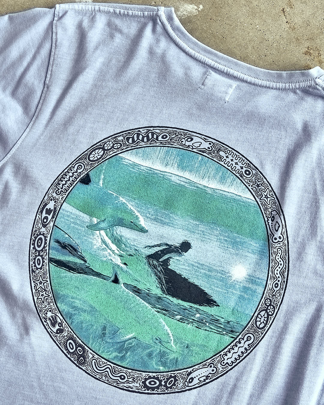 A Dolphin - Limited Edition 35 Years T-Shirt with an image of a surfer on it by Saltrock.