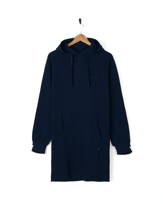 A Saltrock Elsa - Womens Hooded Sweat Dress - Dark Blue, exuding style and comfort, hangs on a wooden hanger.