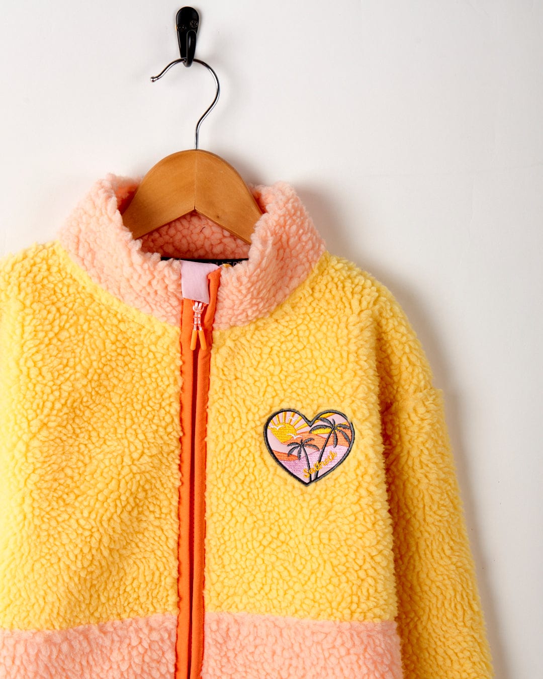 A yellow Emery Sunshine Kids Sherpa Fleece jacket with an embroidered heart graphic by Saltrock.