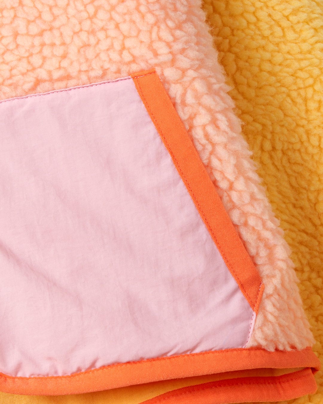 A close up of a Emery Sunshine - Kids Sherpa Fleece - Yellow blanket with colour block panels by Saltrock.