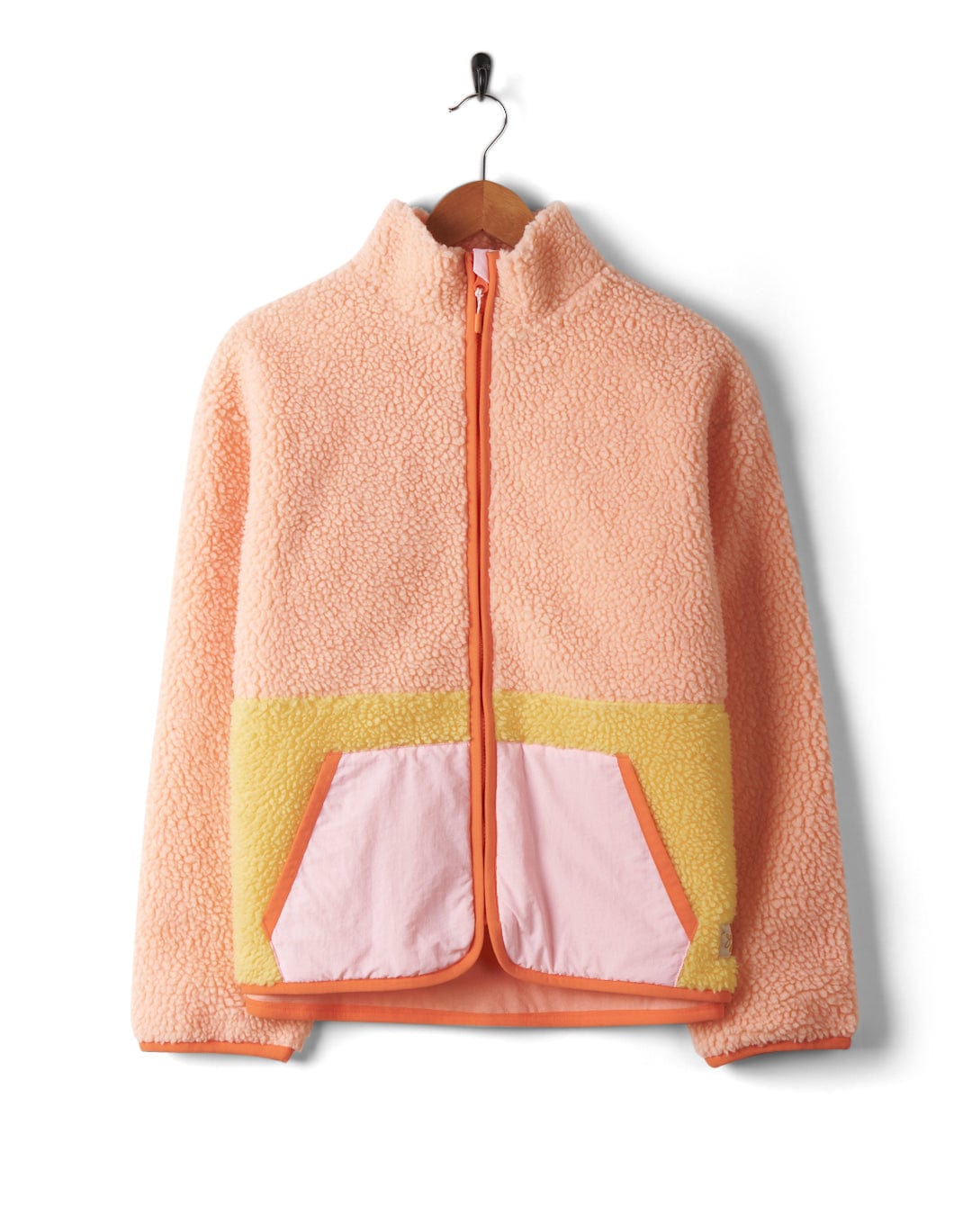 A girl's Emery Sunshine - Womens Sherpa Fleece - Coral jacket with contrast pockets, hanging on a hanger. (Brand Name: Saltrock)