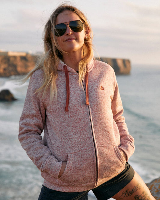 A woman in a Farley - Womens Borg Lined Hoodie in Pink, standing by the ocean from Saltrock.