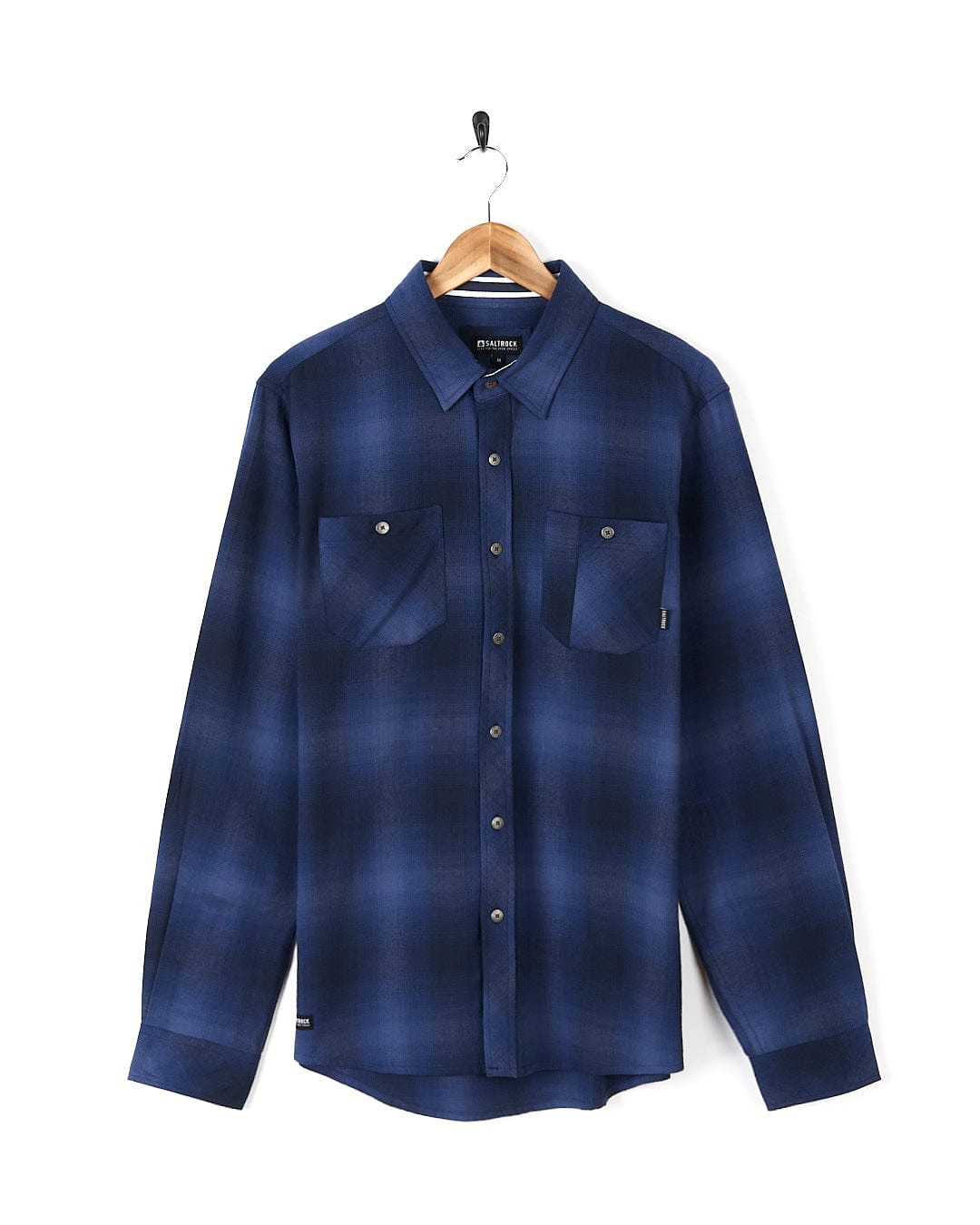 A Farris - Mens Check Shirt - Blue with Saltrock branding, made of 100% cotton, and featuring a blue check pattern, is delicately hanging on a hanger.