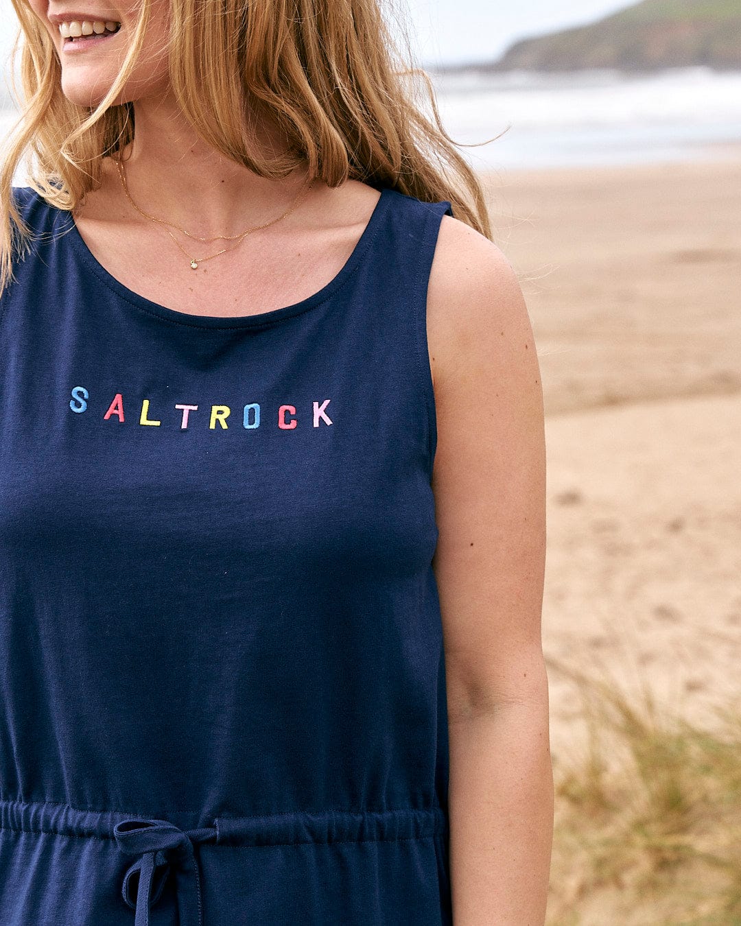 A woman wearing a Flax - Womens Tie Vest Dress - Blue by Saltrock.