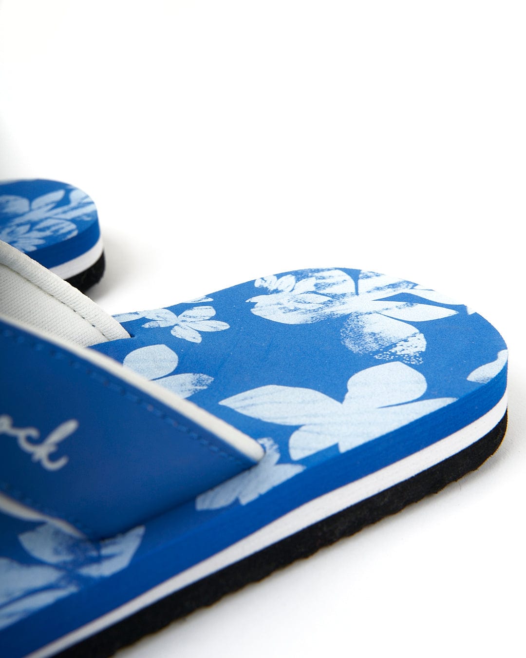 A pair of blue Saltrock Floral - Womens Flip Flops adorned with delicate white flowers.
