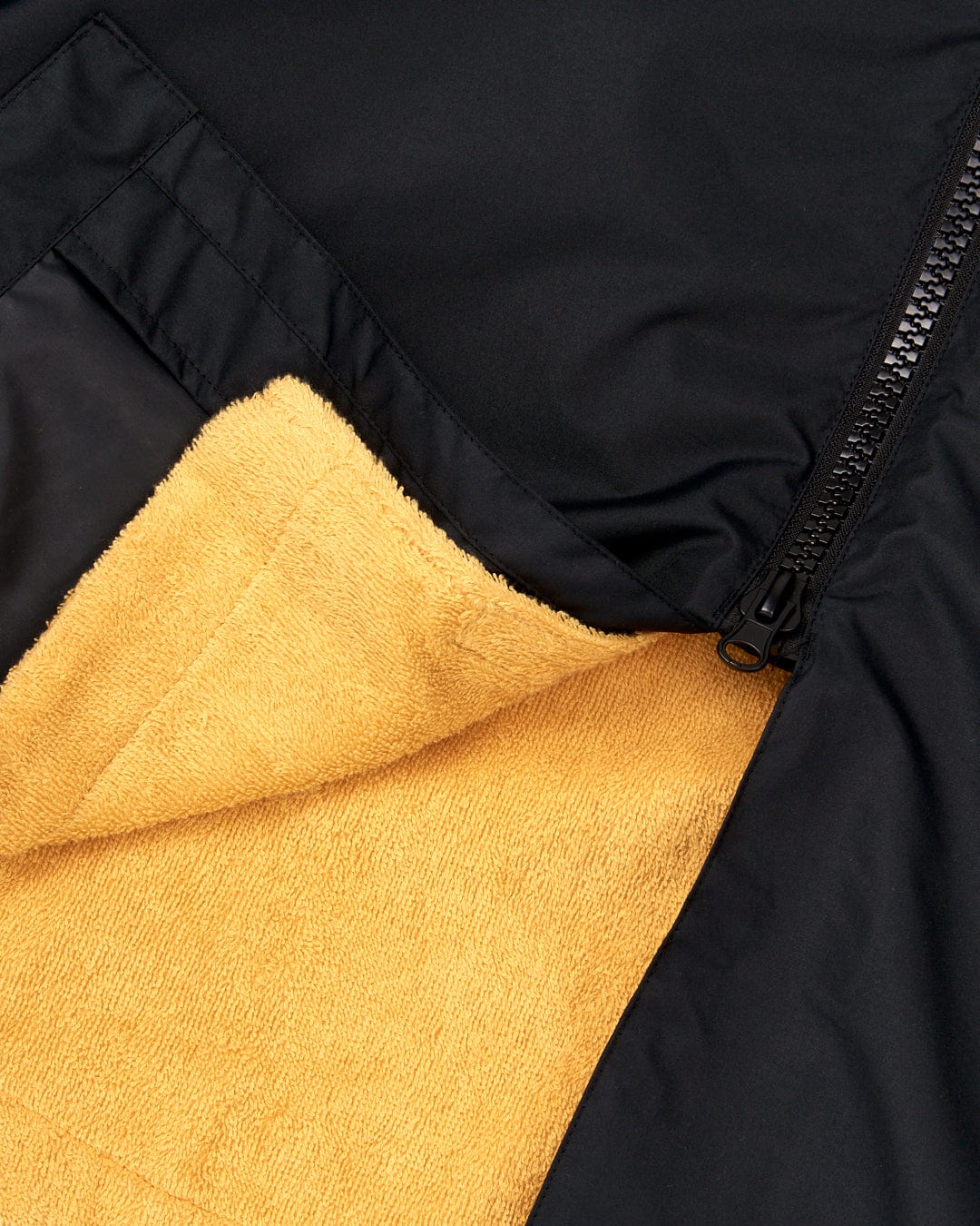 Close-up view of a Saltrock 3 in 1 Recycled Four Seasons Changing Robe - Black/Yellow with a zipper partially open, revealing the yellow towelling lining.