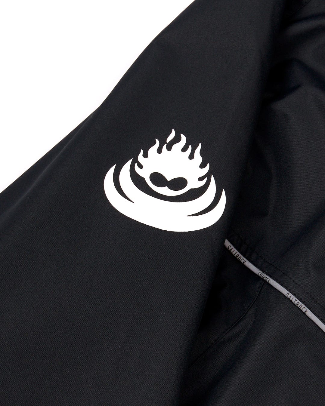 Black fabric with a white stylized logo featuring a flame design, partially obscured by a zipper edge on a Saltrock 3 in 1 Recycled Four Seasons Changing Robe - Black/Yellow.