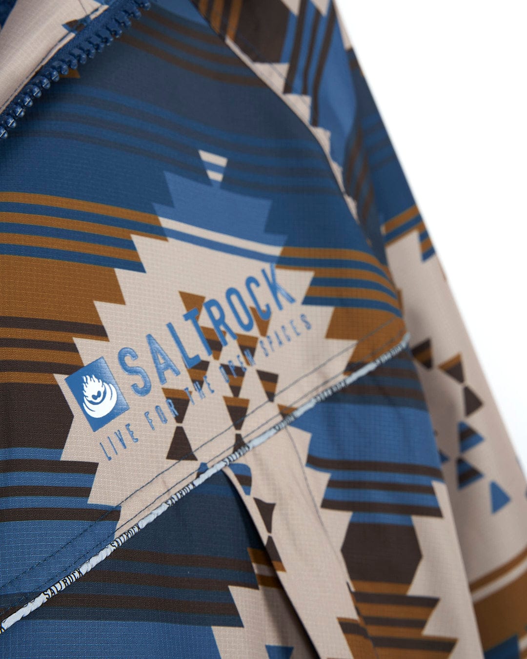 A Saltrock Four Seasons Changing Robe - Aztec blue and brown jacket with a pattern on it.