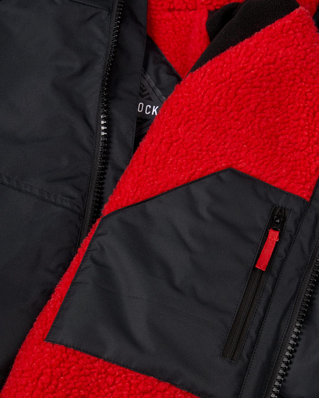 Close-up of a Recycled Kids Changing Robe - Black/Red by Saltrock, crafted from recycled materials, showing a zippered pocket detail.