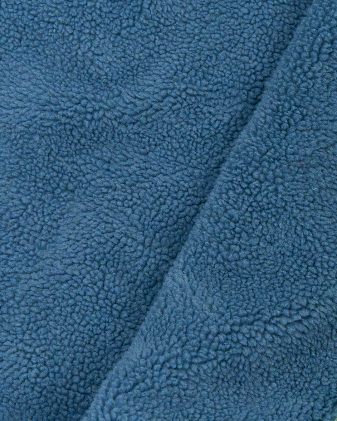 Close-up of a blue textured fabric with a soft, fluffy pile made from the Recycled Four Seasons Changing Robe in Light Green by Saltrock.
