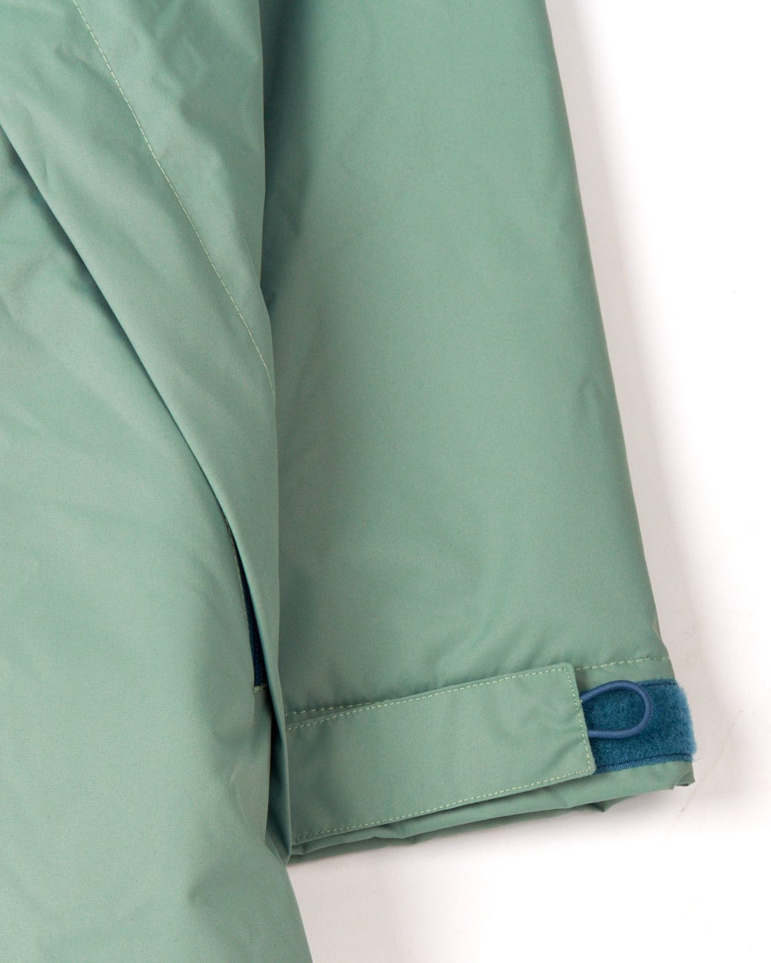 Close-up of a Recycled Four Seasons Changing Robe - Light Green sleeve with blue velcro strap details, made by Saltrock.
