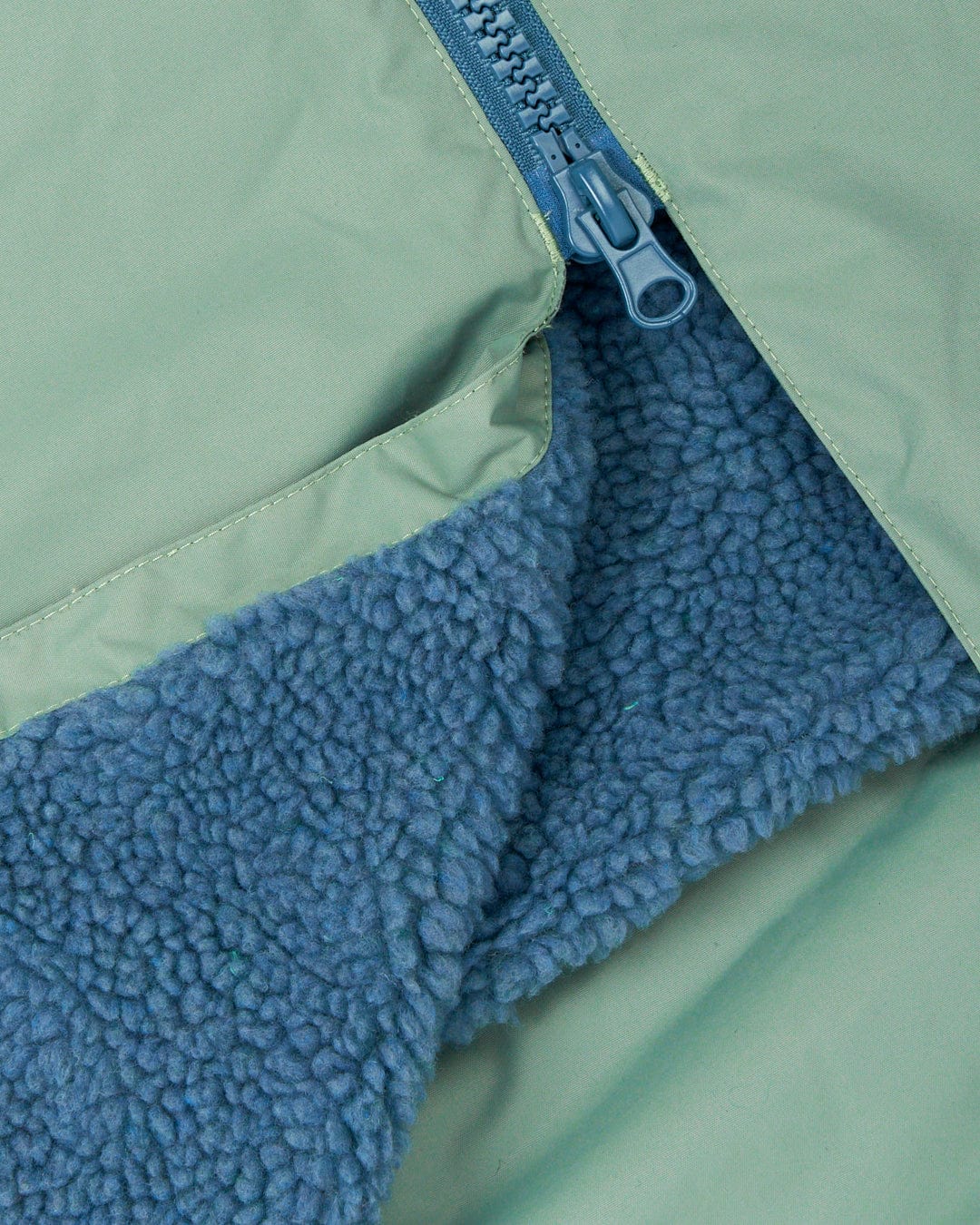 Saltrock's Recycled Four Seasons Changing Robe - Light Green, made from recycled material, with a blue fleece lining and a partially unzipped zipper.