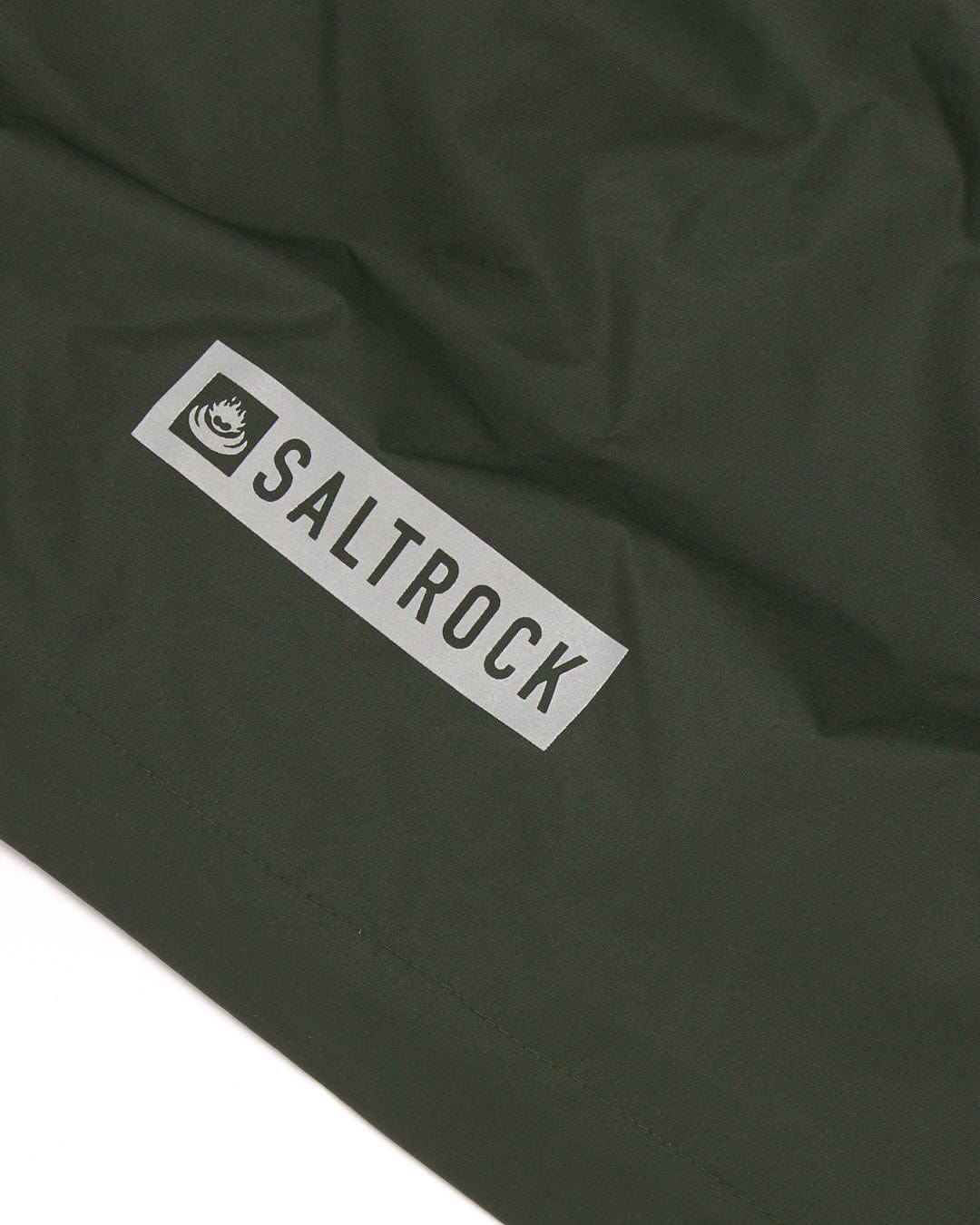 Green fabric with a white Saltrock brand label, made from the Recycled Four Seasons Changing Robe - Green/Aztec.