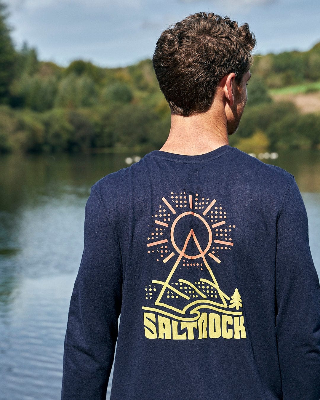 The back of a man wearing a long sleeve shirt that says Saltrock.