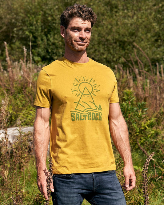 A man standing in a field wearing a Saltrock - Geo Peak Mens Short Sleeve T-Shirt - Yellow.