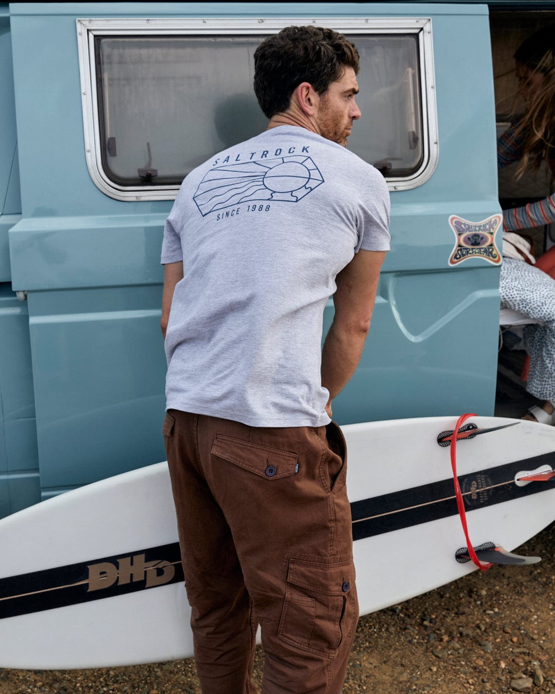 A man with a Saltrock-branded Vantage Outline - Mens Short Sleeve T-Shirt - Grey Marl in the back of a van.