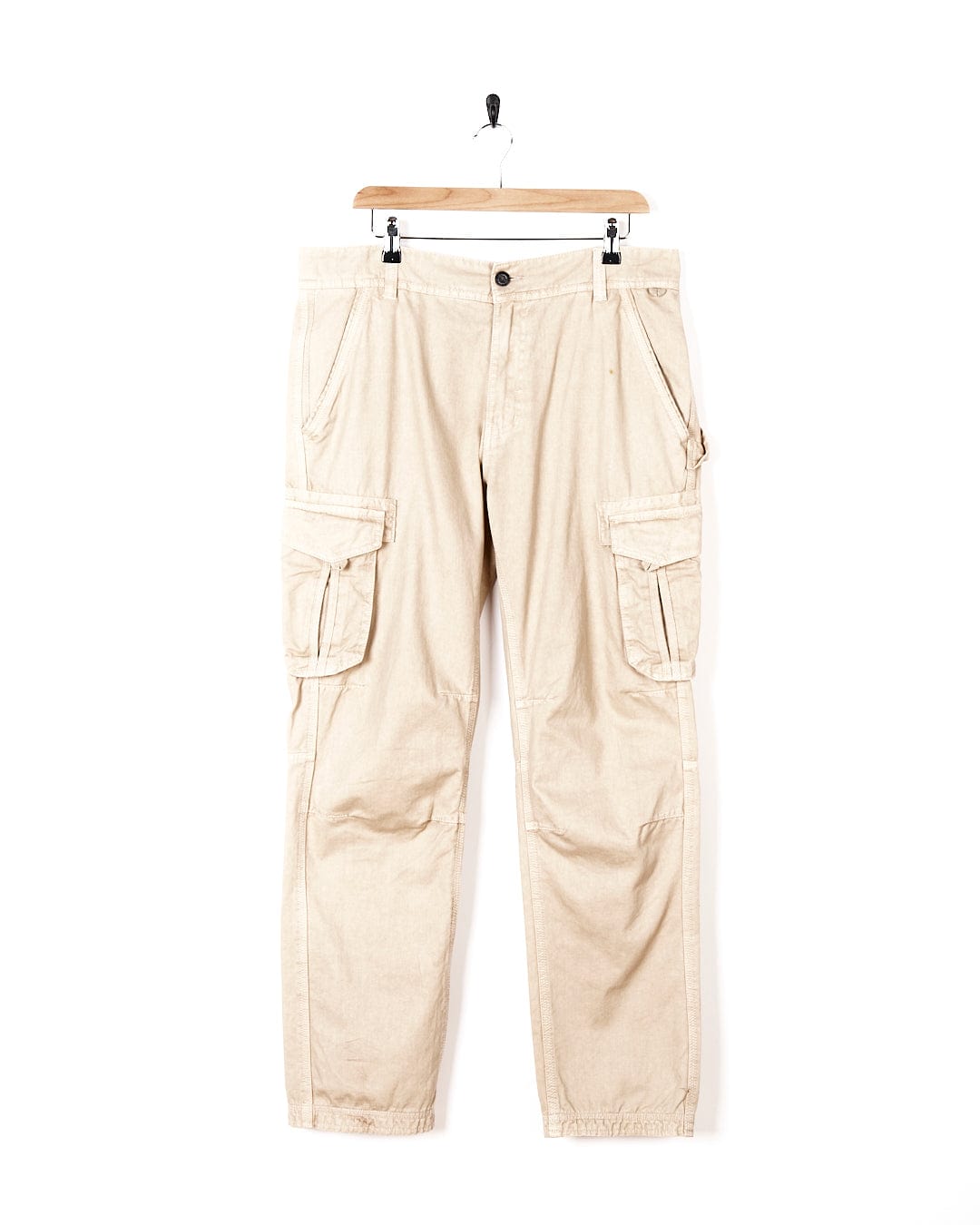 A pair of Godrevy - Mens Cargo Trouser - Sand pants by Saltrock hanging on a hanger.
