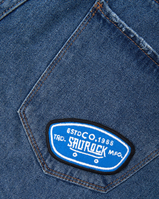 A close up of an embroidered Saltrock patch on a pair of jeans.