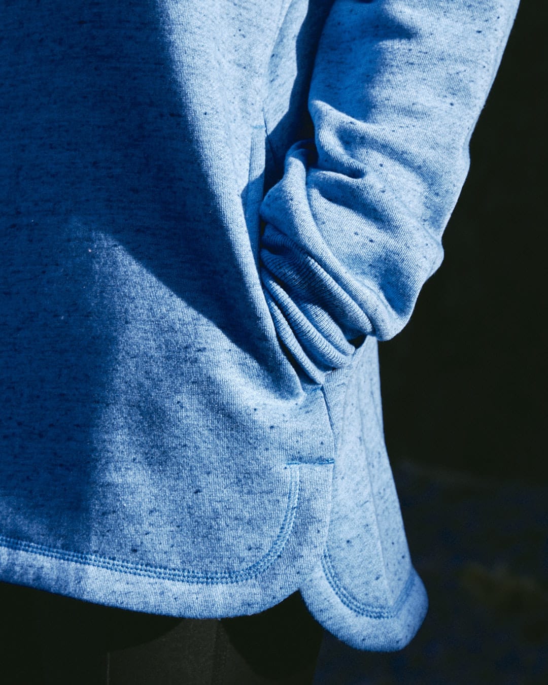 A chic woman wearing a Saltrock Harper - Womens Longline Pop Sweat - Light Blue sweatshirt, looking comfortable.