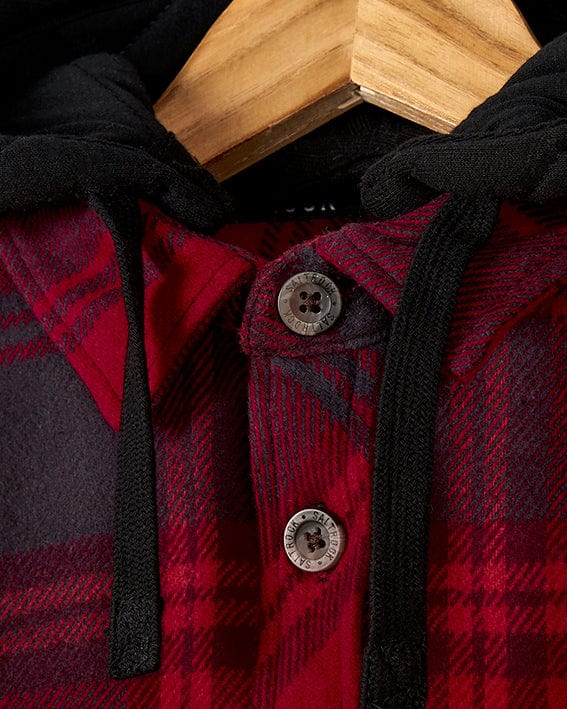 A red and black plaid Hawkins - Hooded Long Sleeve Check Shirt - Red with Saltrock branding, made from durable cotton fabric. The Hawkins - Hooded Long Sleeve Check Shirt - Red also features a detachable hood, providing versatility to the wearer.