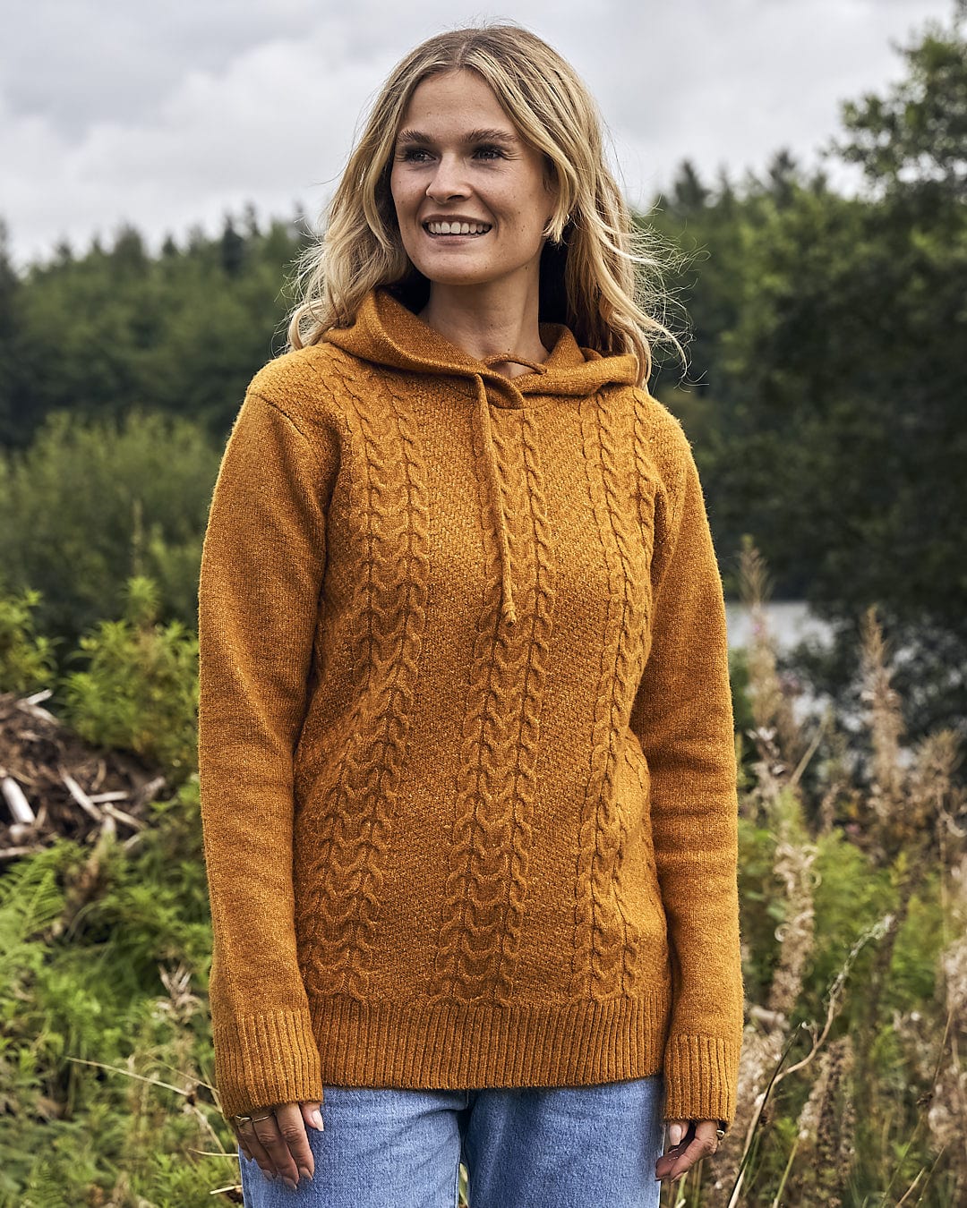 A woman in a Saltrock Hele Bay 2 - Womens Knitted Jumper - Yellow standing in a field.