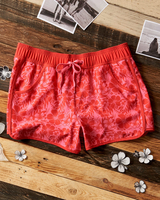A pair of Saltrock women's shorts with a floral print on a wooden table.