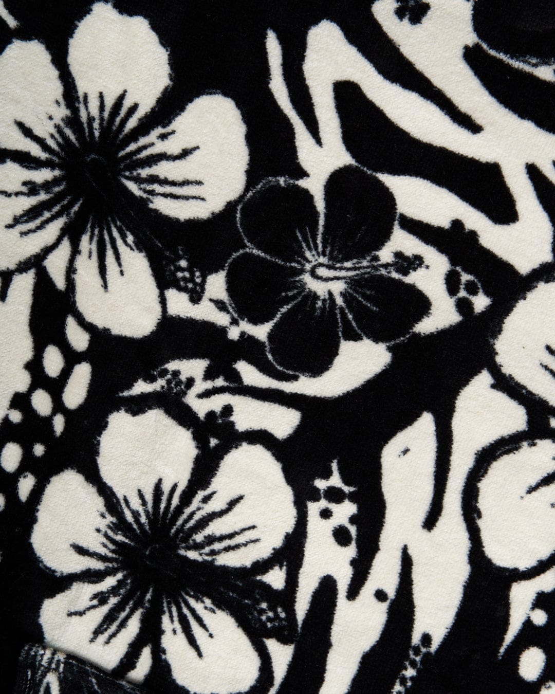 Close-up view of a Saltrock Hibiscus Changing Towel - Black/White fabric texture featuring a black and white floral pattern.