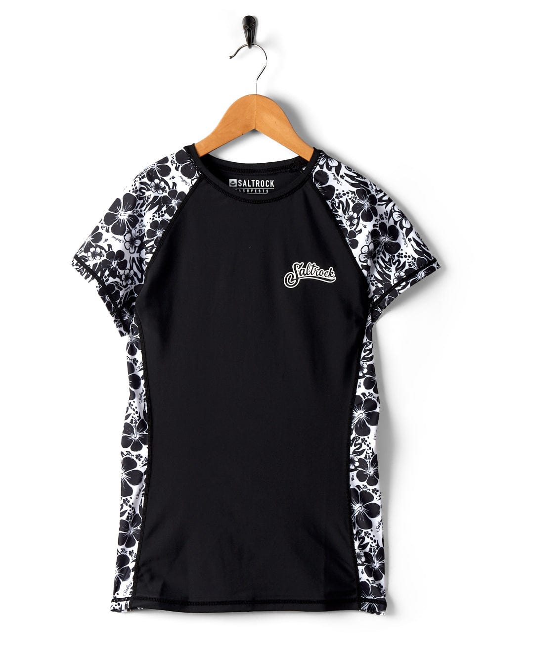 Black and white Saltrock Hibiscus - Recycled Womens Short Sleeve Rashvest with Hibiscus pattern sleeves and logo, hanging on a wooden hanger against a white background.