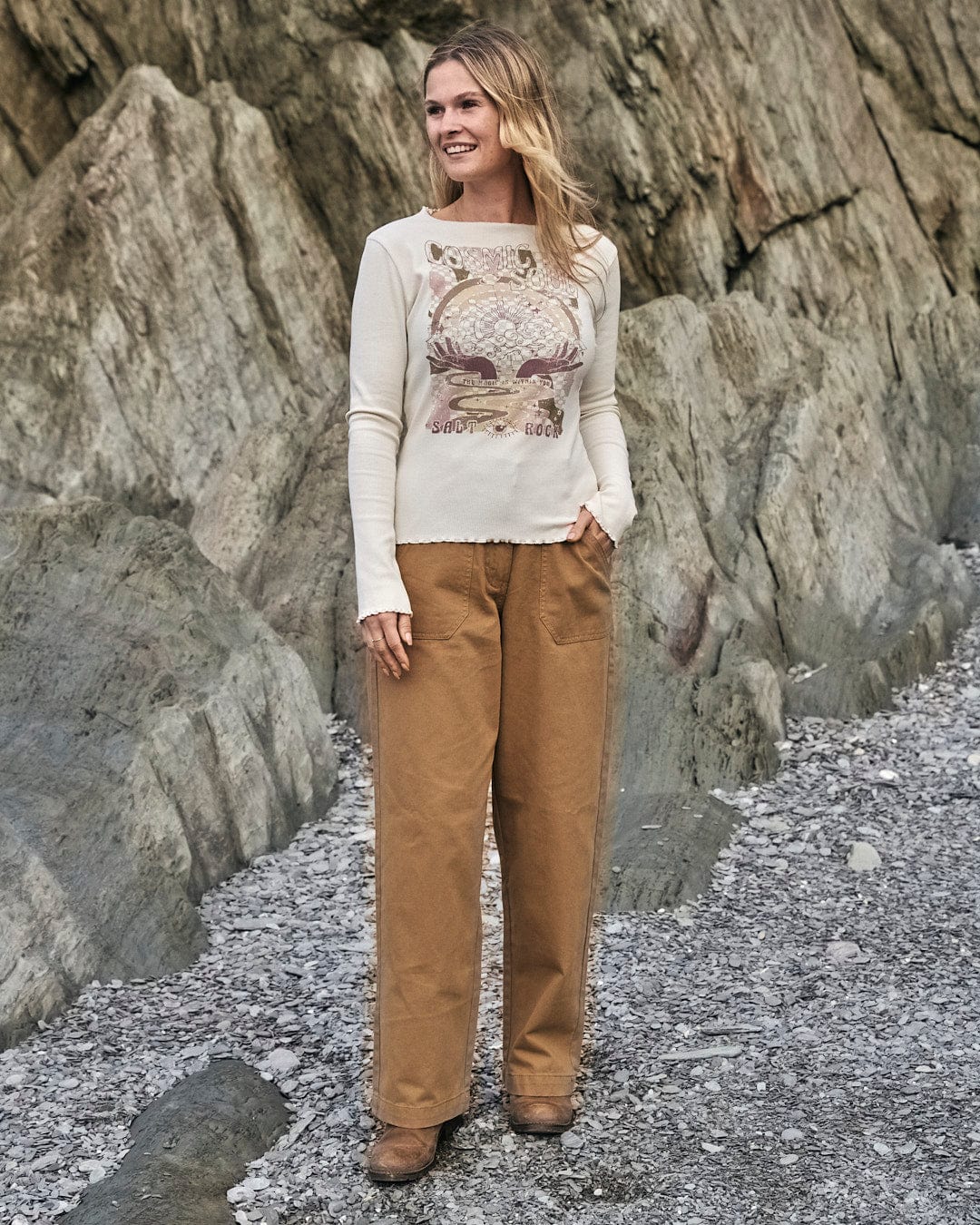 A woman in comfortable Saltrock Hilda Twill - Womens Trouser - Light Brown standing on a rock.