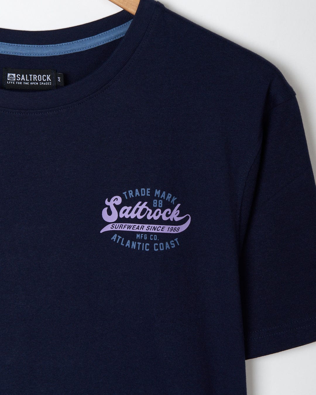 Close-up of a dark blue cotton Saltrock Home Run t-shirt with branding on the chest.