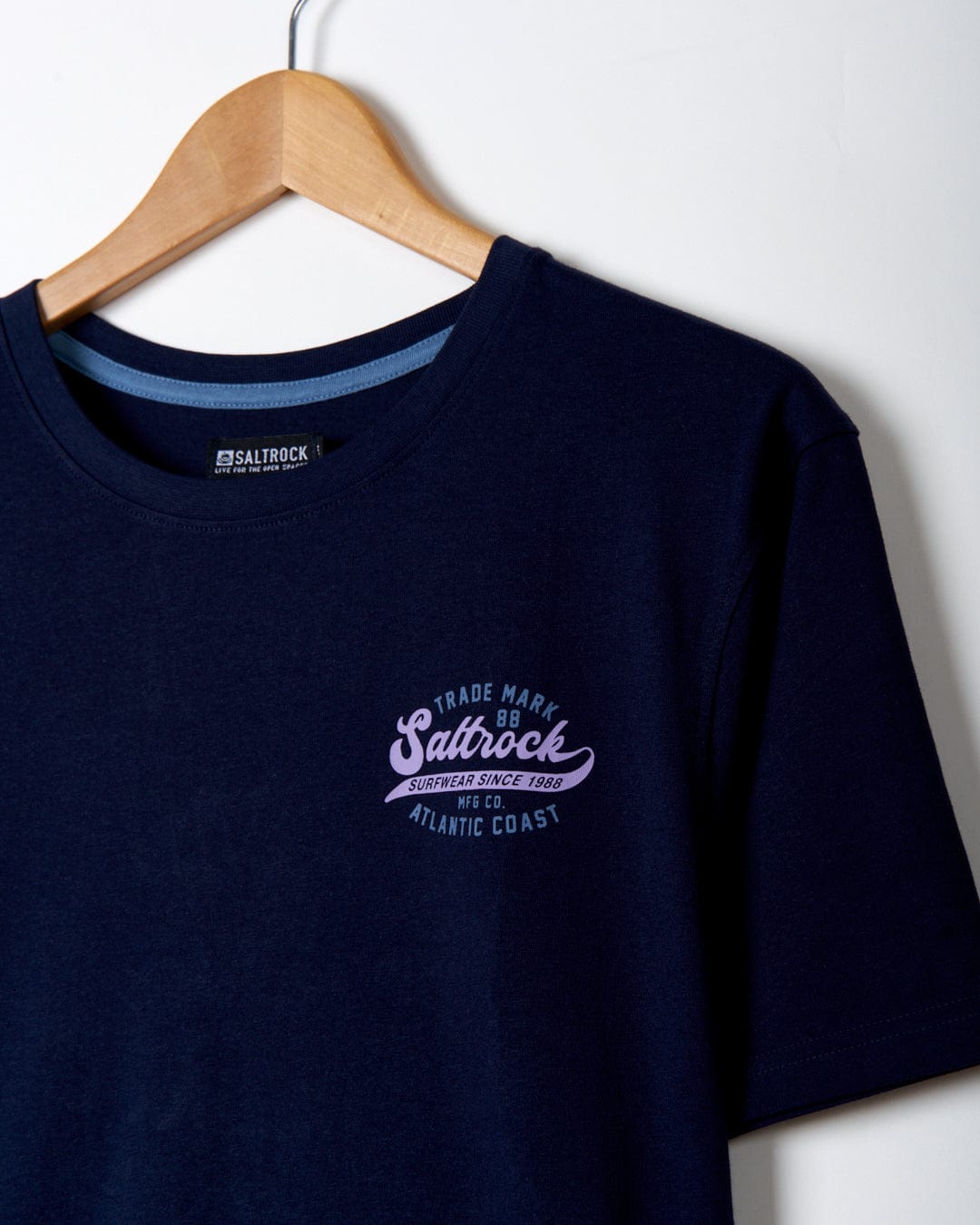 Home Run - Mens Short Sleeve T-Shirt - Dark Blue with Saltrock branding on a wooden hanger against a white background.