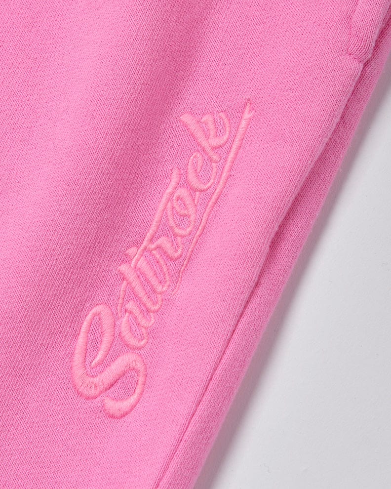 Close-up of pink Instow - Womens Jogging Bottom with the word "Saltrock" embroidered in cursive script.