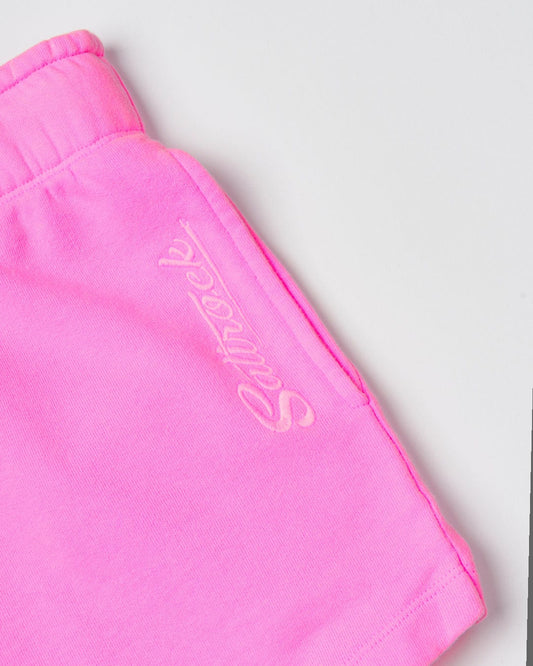 Close-up of a pink fabric showing a cursive "Instow - Womens Sweat Shorts - Pink" logo embroidered in a slightly darker pink tone, made from 100% cotton by Saltrock.