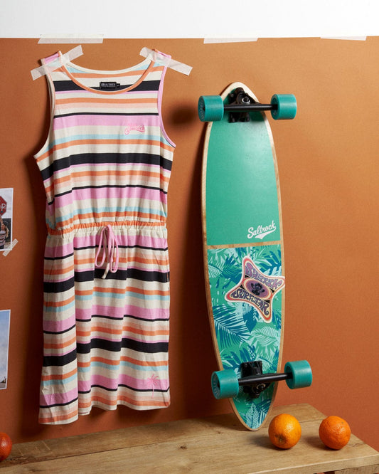 A Saltrock skateboard, a Juno Bauhaus - Womens Stripe Dress - Multi, and oranges on a table.