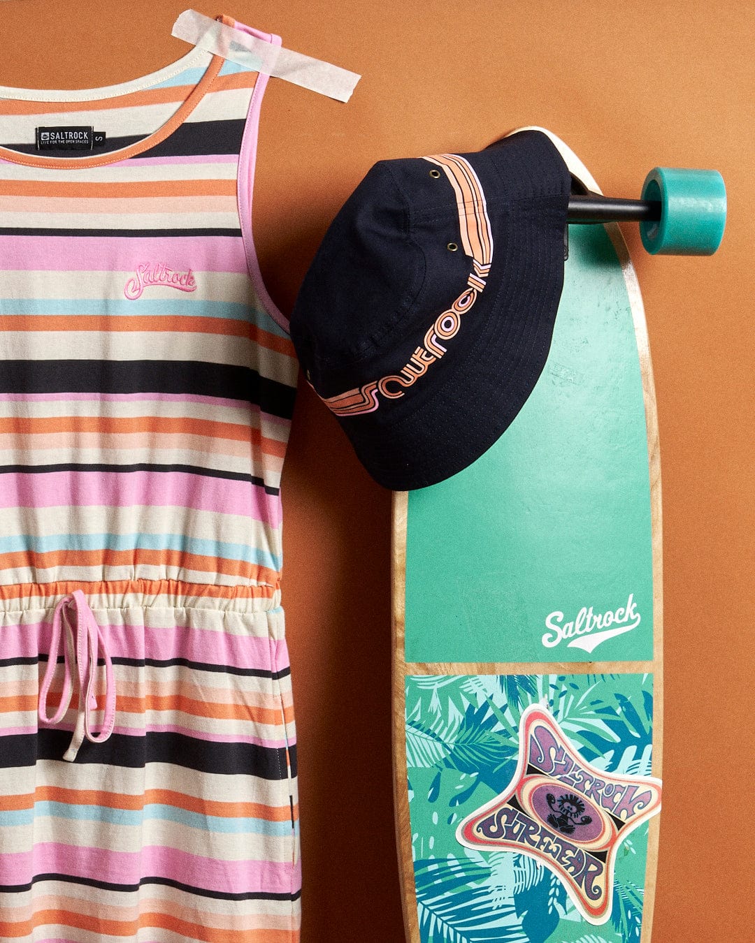 A Juno Bauhaus - Womens Stripe Dress - Multi from Saltrock with a skateboard and hat.