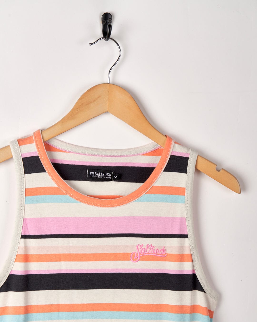 Colorful striped Juno midi dress on a wooden hanger against a white background. The dress features pink, orange, and gray stripes with a visible Saltrock label and an embroidered palm tree.