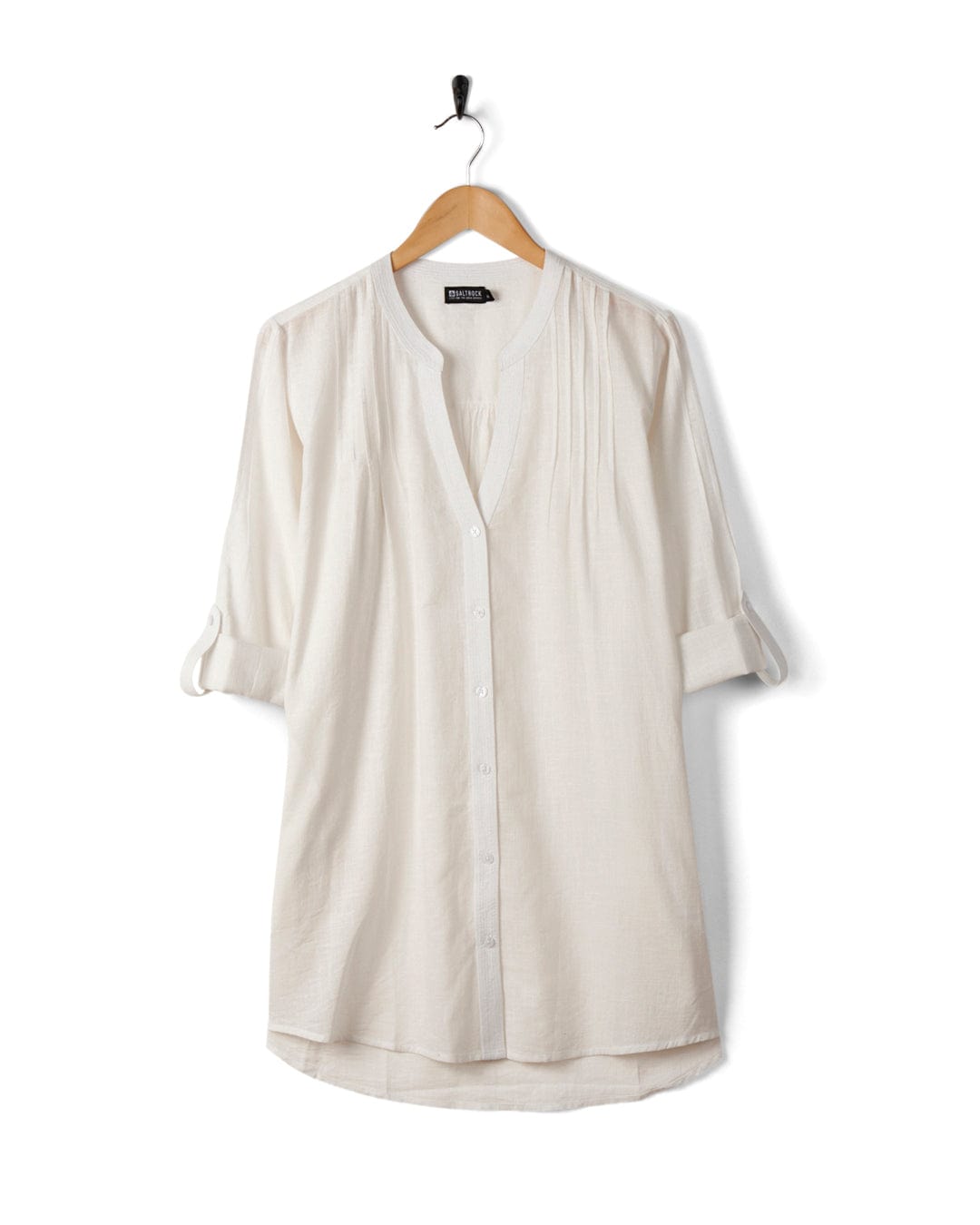 A cream-colored cotton blouse with 3/4 sleeves and button-down front, hanging on a black hanger against a white background.