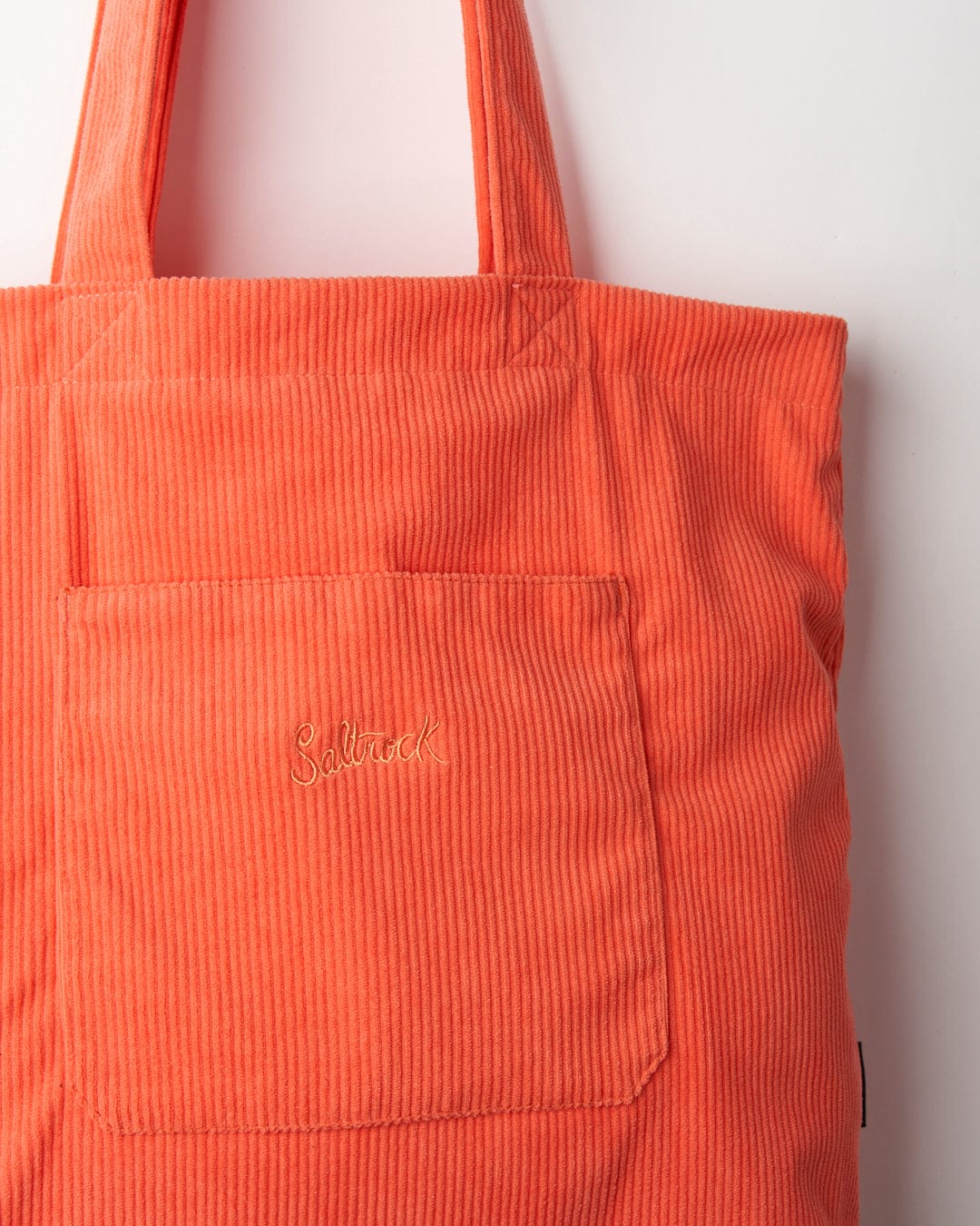 Close-up of a Laguna Cord Shopper Bag - Coral with shoulder straps and a stitched Saltrock branding label.
