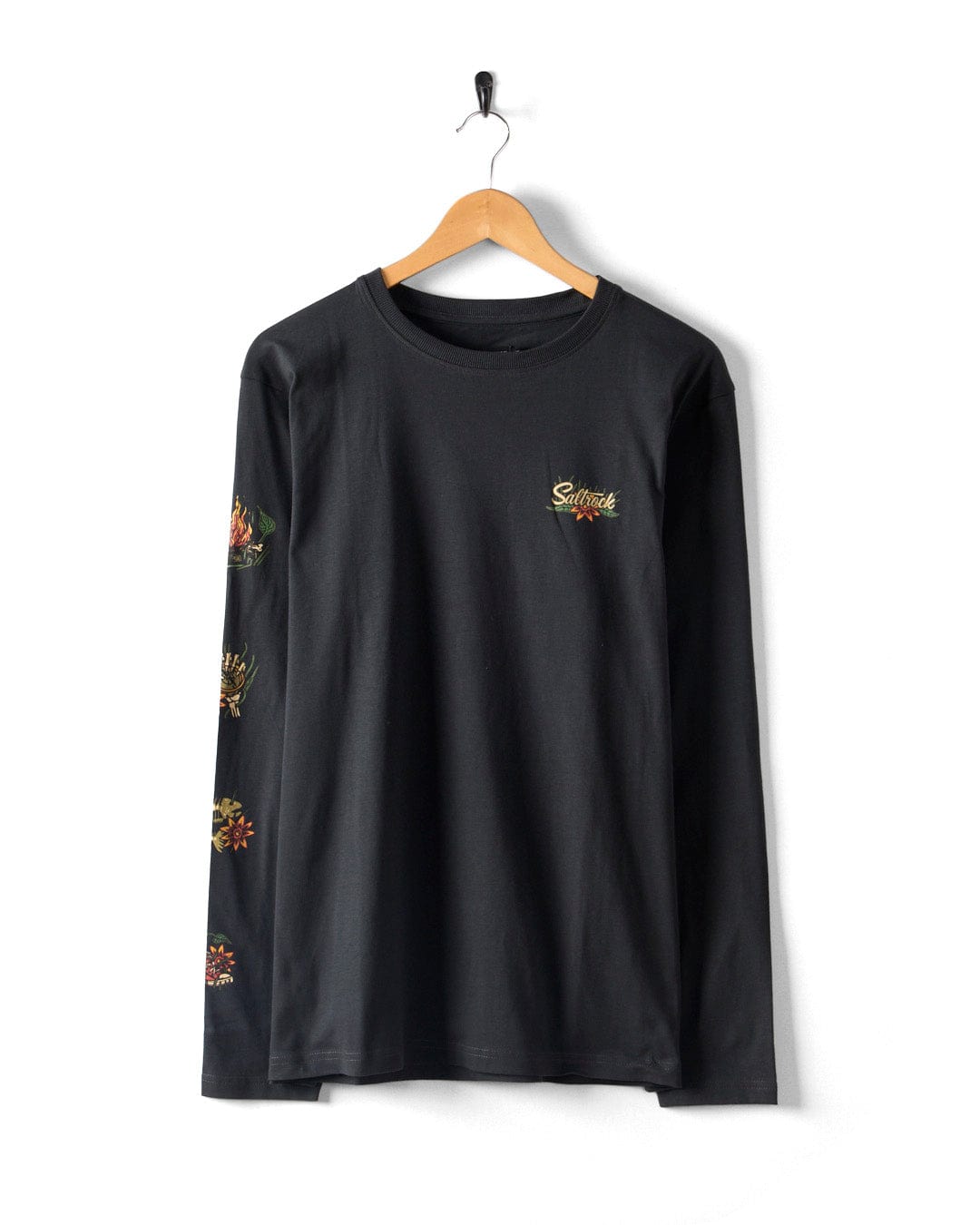 The Lantern Men's Dark Grey Long Sleeve T-Shirt by Saltrock, made from 100% cotton, elegantly hangs on a wooden hanger. It showcases a small "Sunset" logo on the chest and features signature floral patterns on the sleeves.