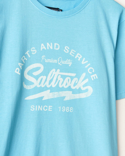 Close-up of a light blue Last Stop Motel t-shirt with the white Saltrock branding "parts and service premium quality since 1988.