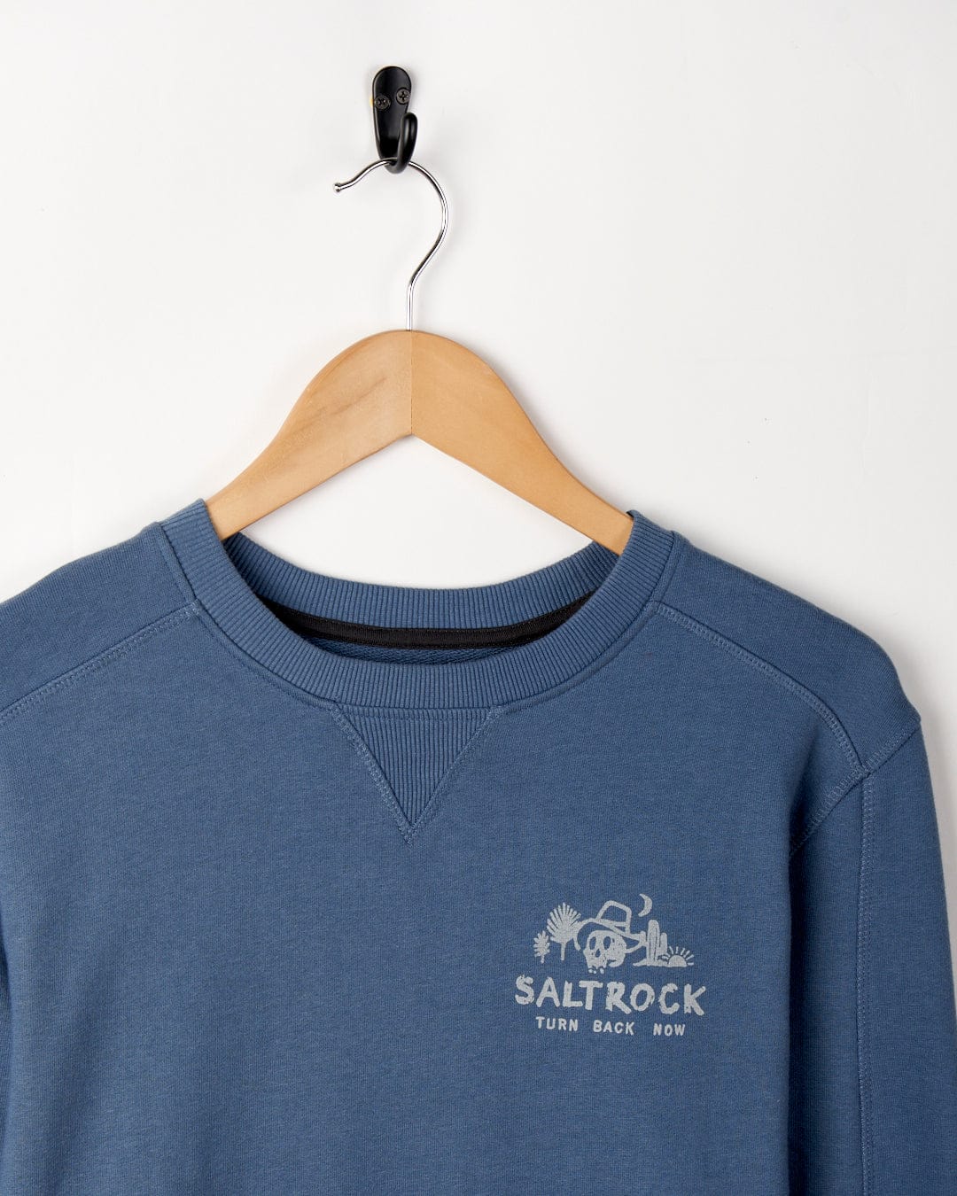 A Last Stop Motel - Recycled Mens Sweatshirt - Blue sweatshirt with a crew neckline hangs on a wooden hanger against a plain white background.