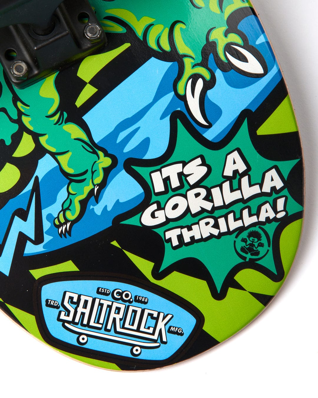 The image features a durable skateboard deck with colorful graphics of a green gorilla claw and text that reads, "ITS A GORILLA THRILLA!" and "SCTRCO Estd. Saltrock Mfg." The Las Vegas Smackdown - Skateboard - Green/Blue by Saltrock adds vibrant energy to the design.