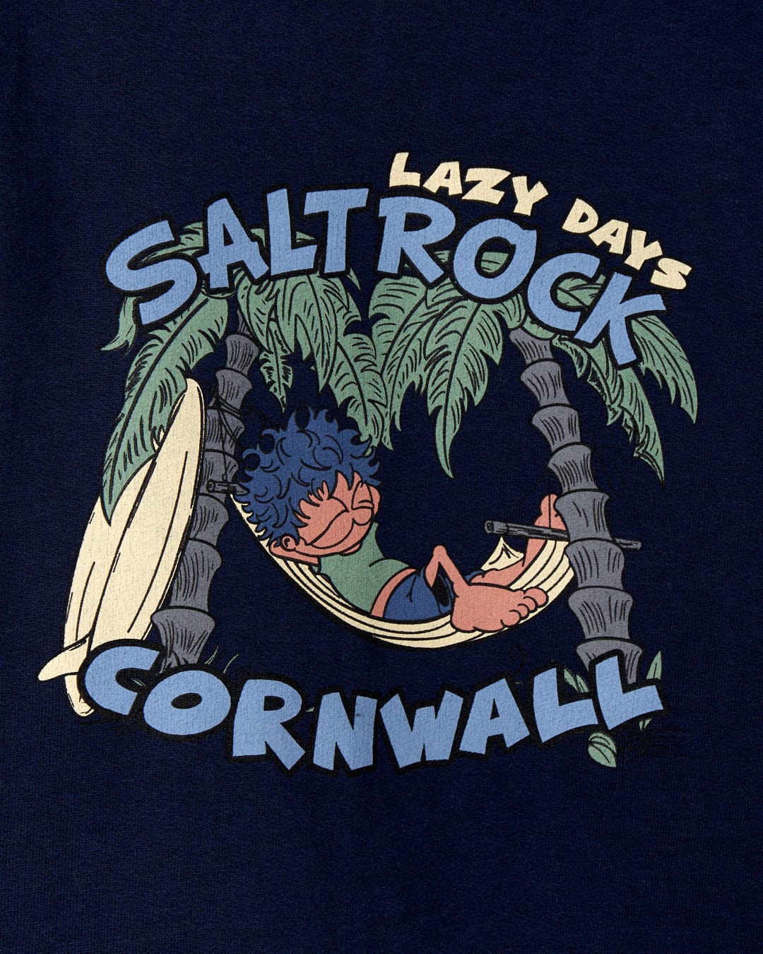 Graphic designed message "Lazy Location Cornwall - Recycled Kids Hoodie - Blue Saltrock" featuring two cartoon characters lounging in a hammock between palm trees on a navy blue background.