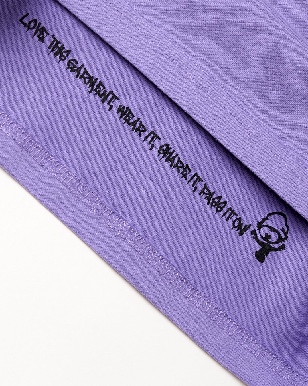A purple Cotton fabric with black text featuring Saltrock surfing graphics.