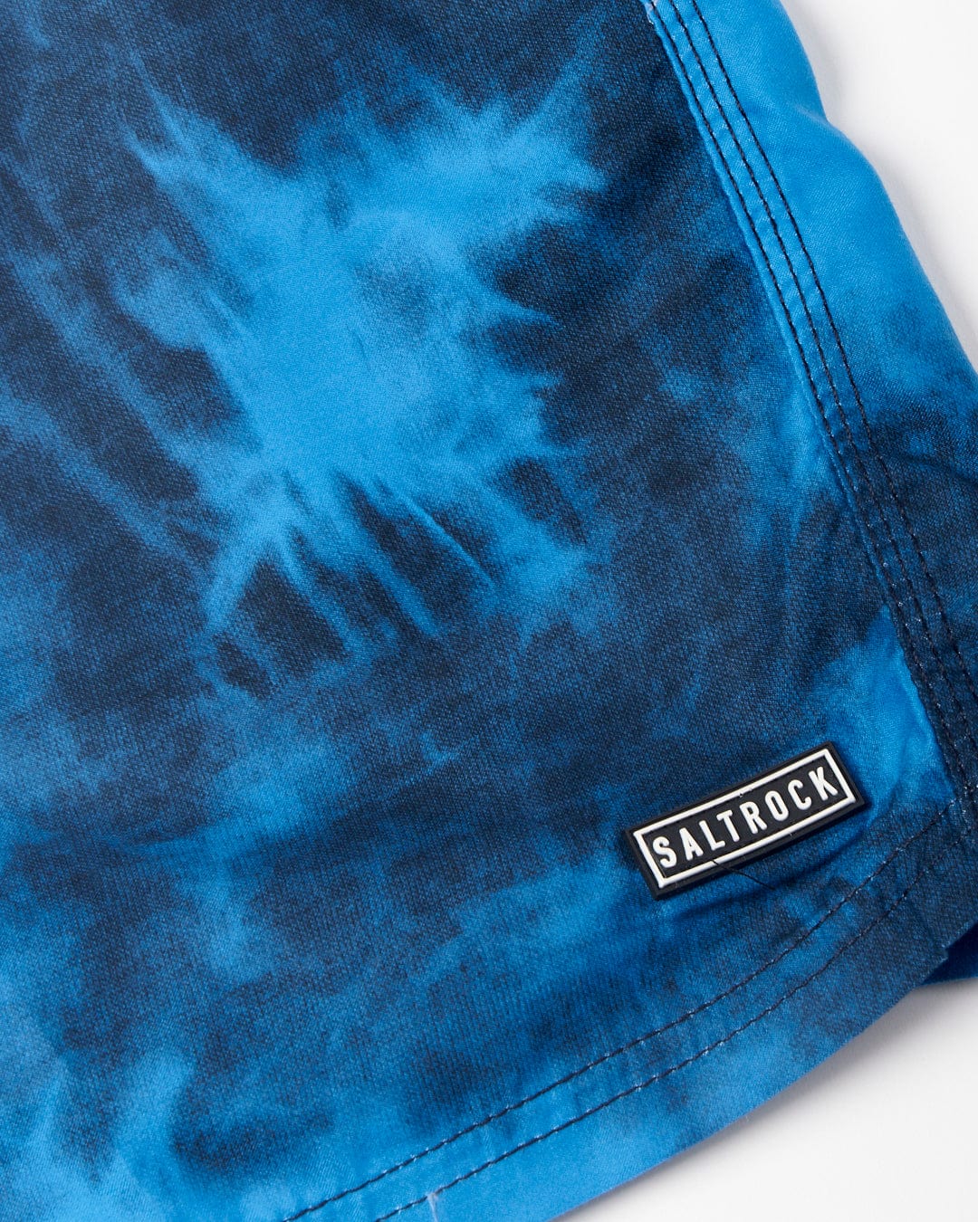 Close-up of a Lee - Mens Tie Dye Swimshorts - Blue fabric with a Saltrock logo tag.