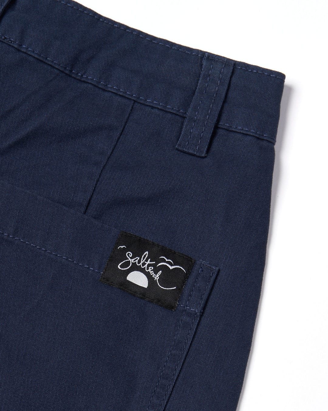 Navy blue Liesl chino shorts with a Saltrock branded label on the pocket.